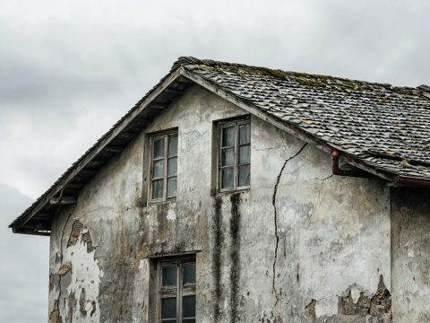 Muro exterior con pintura descascarada por humedad